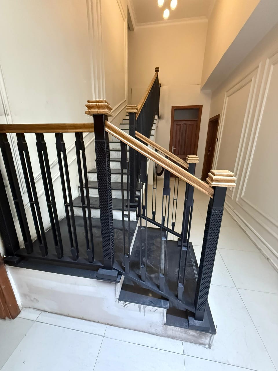 Grand marble interior staircase with architectural geometric metal balustrade